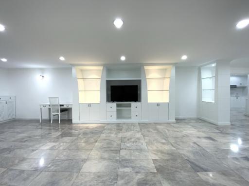 Spacious and modern living room with tiled flooring and built-in shelving