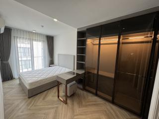 Modern bedroom interior with large bed, wardrobe, and desk