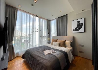 Spacious bedroom with large windows and city view