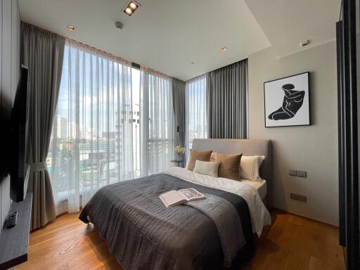 Spacious bedroom with large windows and city view