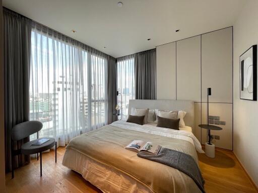 Modern bedroom with large windows and city view