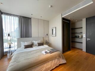 Contemporary bedroom with city view, natural light, and hardwood floors