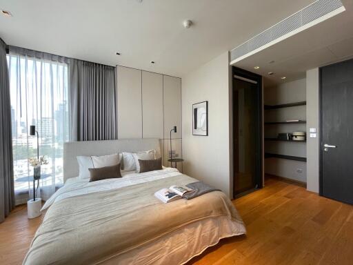 Contemporary bedroom with city view, natural light, and hardwood floors