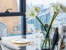 Elegantly set dining table with a city view through large windows