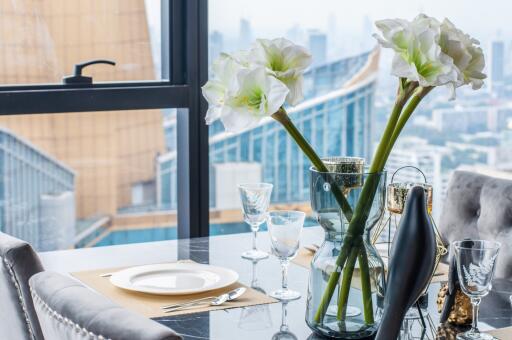 Elegantly set dining table with a city view through large windows