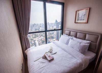 Cozy bedroom with a cityscape view through a large window