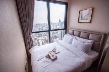 Cozy bedroom with a cityscape view through a large window