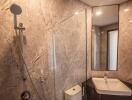 Modern bathroom with marble walls and glass shower