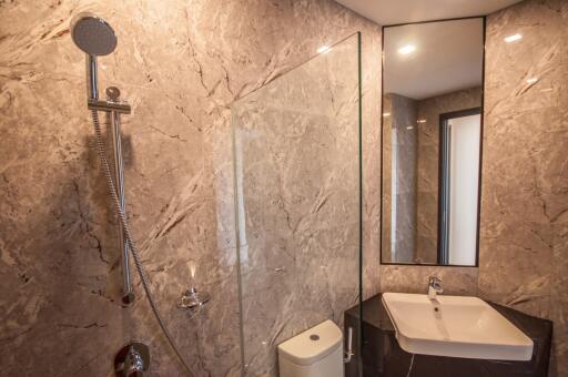 Modern bathroom with marble walls and glass shower