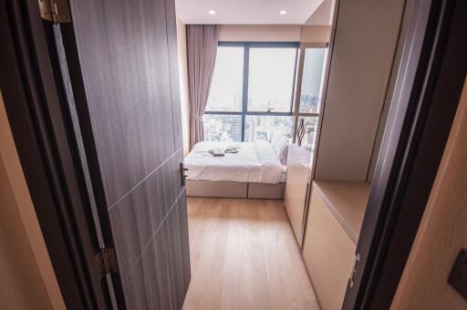 Cozy bedroom with a view of the city through large windows