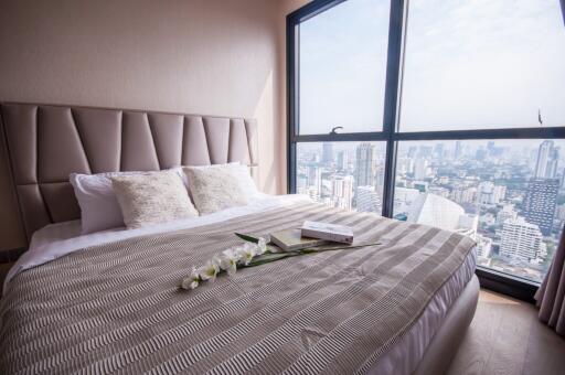 Modern bedroom with city view through large window