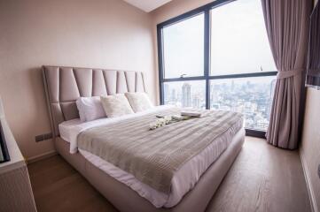 Modern bedroom with a large window offering a city view