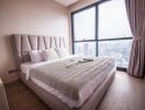 Modern bedroom with a large window offering a city view