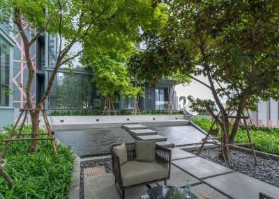 Modern outdoor seating area with green landscaping and contemporary building facade