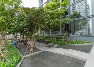 Modern building exterior with green landscaping and sitting area