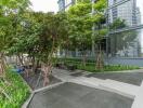 Modern building exterior with green landscaping and sitting area