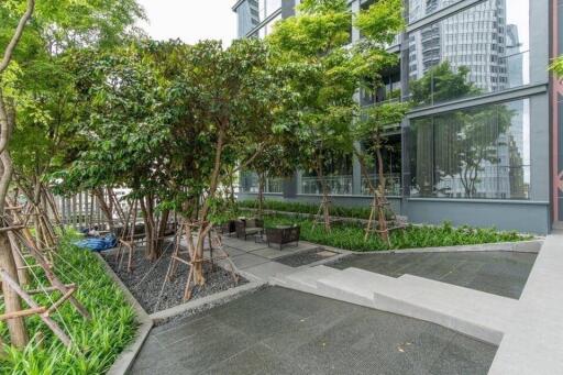 Modern building exterior with green landscaping and sitting area