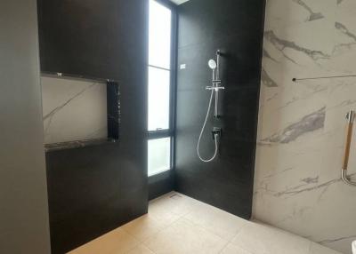 Modern bathroom interior with marble walls and a glass shower section