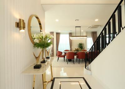 Modern dining area with marble flooring, staircase, and elegant decor