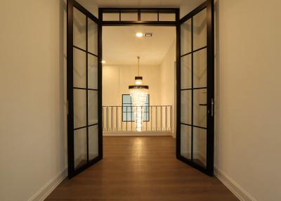 Modern hallway with glass panel doors and pendant lighting