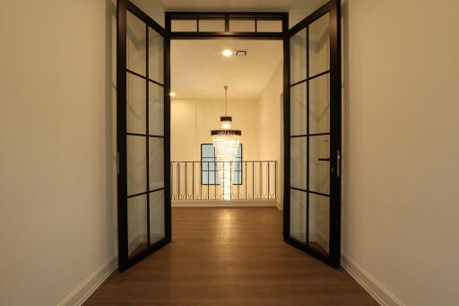 Modern hallway with glass panel doors and pendant lighting