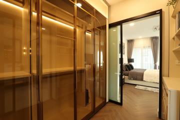 Elegant bedroom with mirrored wardrobe and sliding door leading to cozy living area