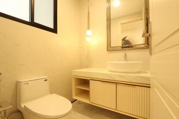 Modern bathroom interior with marble walls and wooden vanity