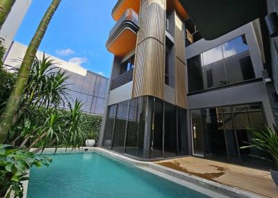 Modern house with a private pool and wooden deck surrounded by tropical plants