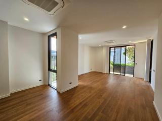 Spacious and well-lit living room with hardwood floors and balcony access