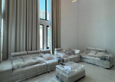 Newly furnished living room with high ceiling and modern chandelier