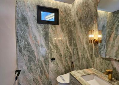 Modern bathroom with marble walls and gold fixtures