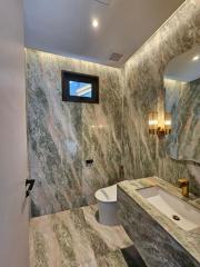 Modern bathroom with marble walls and gold fixtures