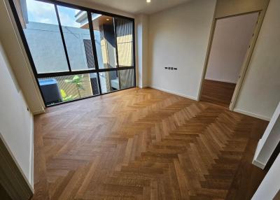 Spacious bedroom with large window and parquet flooring