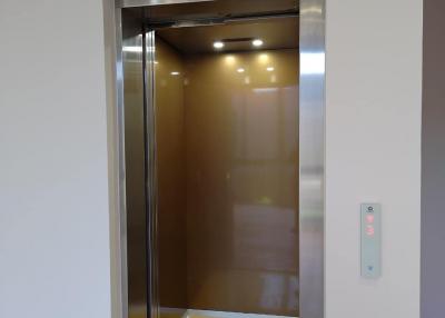 Residential elevator with open doors showing interior cabin lights