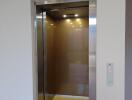 Residential elevator with open doors showing interior cabin lights