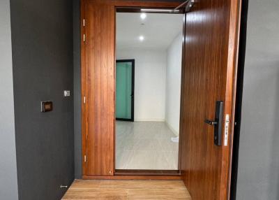Modern entryway with open wooden door and tiled flooring