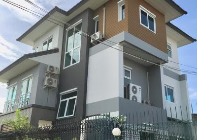Modern two-story house with external air conditioning units and balcony