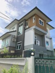 Modern two-story house with external air conditioning units and balcony