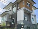 Modern two-story house with external air conditioning units and balcony