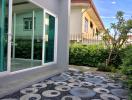 Paved pathway leading to a green house with a cozy front yard