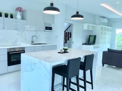 Modern kitchen with integrated appliances, an island with seating, and an open plan layout