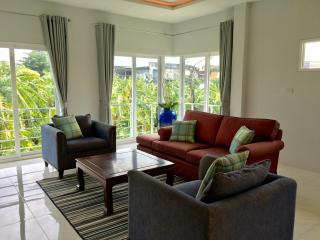 Spacious and Bright Living Room with Large Windows and Comfortable Seating