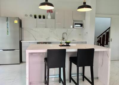 Modern kitchen with a marble island and black stools