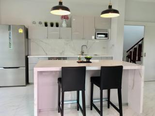 Modern kitchen with a marble island and black stools