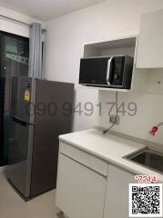Compact modern kitchen with refrigerator, microwave, and sink