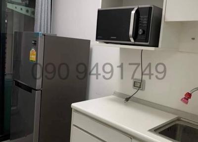 Compact modern kitchen with refrigerator, microwave, and sink
