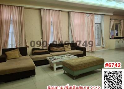 Spacious living room with large windows and comfortable seating