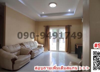 Spacious and well-lit living room with comfortable seating and large windows