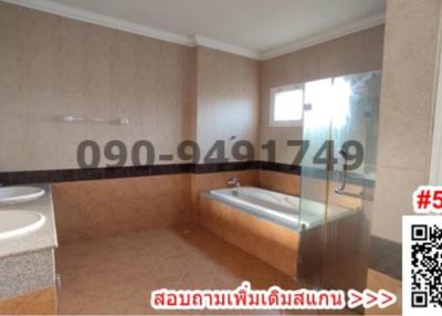 Spacious bathroom with dual sinks, bathtub and separate shower area