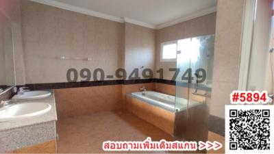 Spacious bathroom with dual sinks, bathtub and separate shower area